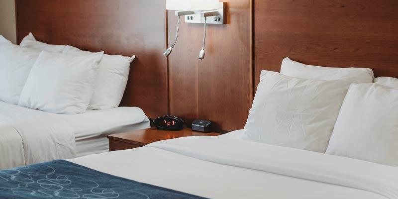 Two beds in a hotel room with wood paneled walls