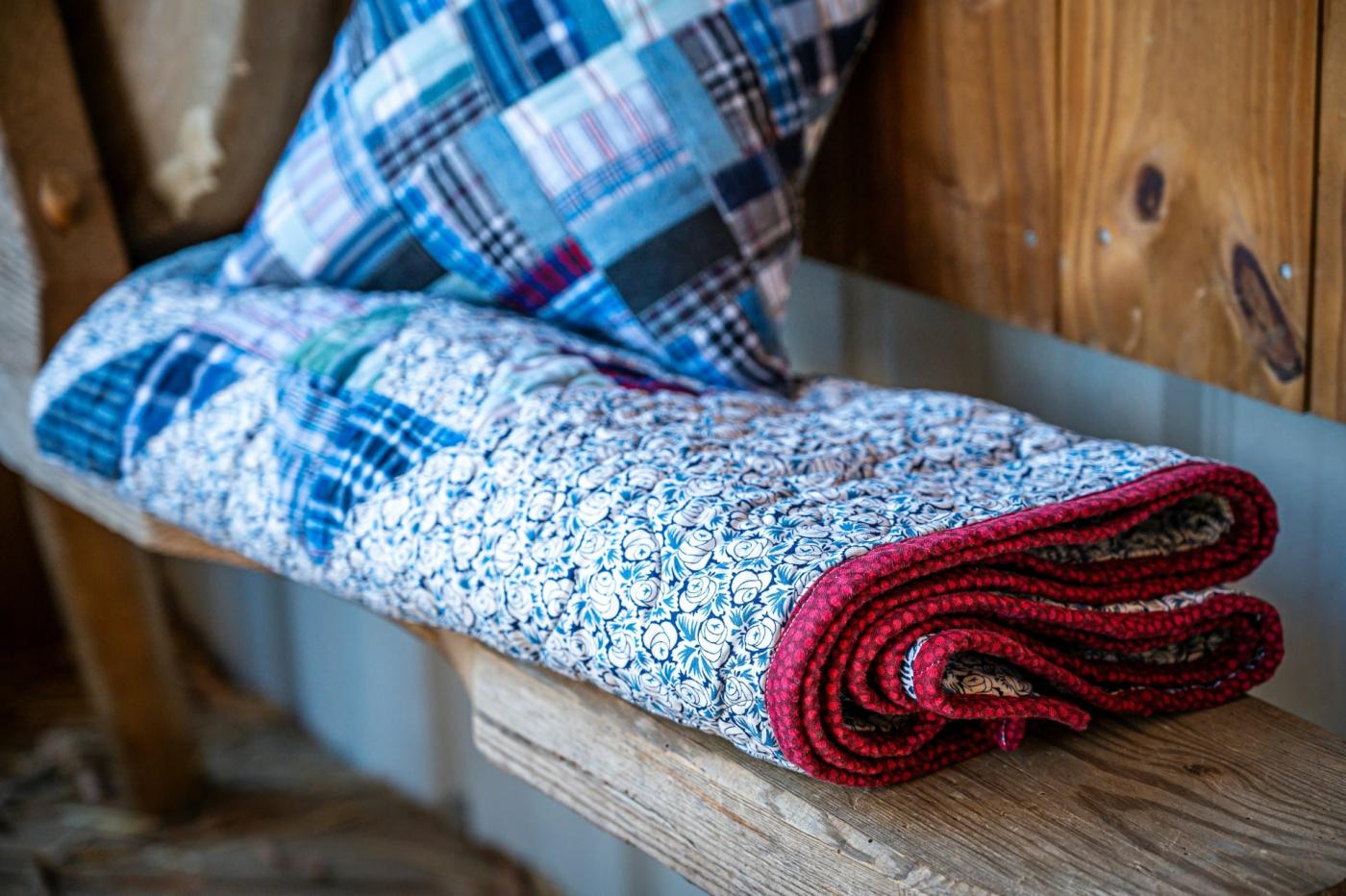 Quilted blanket and pillow on a bench